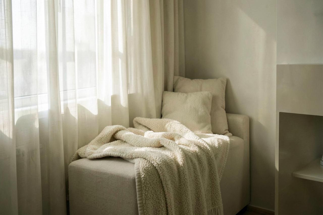 A quiet window seat with a soft blanket in natural light